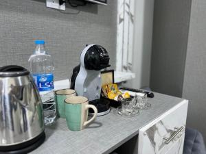 a kitchen counter with a mixer and cups and a bottle of water at Downtown Inn Madaba in Madaba