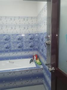 y baño azul y blanco con bañera. en A B C Hotel en Udawalawe