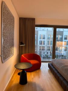 una habitación de hotel con una silla roja y una ventana en Townhouse Alaunpark, en Dresden
