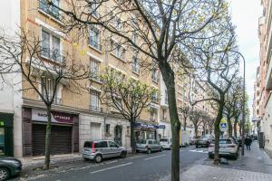 uma rua da cidade com carros estacionados em frente a um edifício em MBA Splendide Appart - Mowat - Proche Château de Vincennes em Vincennes