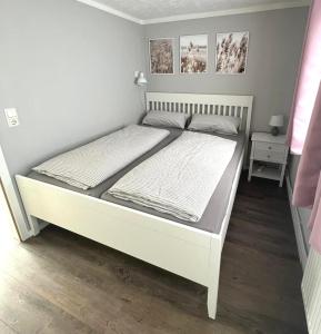 a bed in a bedroom with a white bed frame at Boddenferienhaus - 12 Molenfeuer in Schaprode