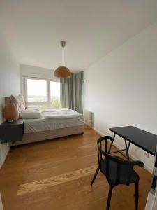 ミエルノにあるApartament przy plaży 9のベッドとテーブルと窓のある寝室