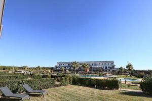 een uitzicht op een resort met 2 stoelen en een zwembad bij Bajo con vistas increíbles in El Rompido