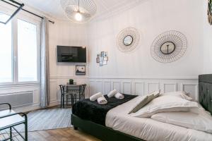um quarto branco com uma cama e uma mesa em MBA Splendide Appart - Mowat - Proche Château de Vincennes em Vincennes