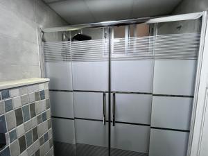 a shower stall in a bathroom with a glass door at Downtown Inn Madaba in Madaba