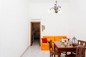 - un salon avec une table et un canapé jaune dans l'établissement Casa Vacanze Petronia-By Faendho, à Porto Torres