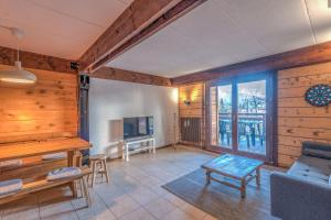 un soggiorno con un divano e una TV di ArboRêve - Station de ski à pied vue montagne a Megève