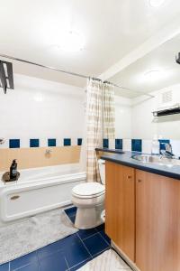 uma casa de banho com um WC, um lavatório e uma banheira em loft in downtown Vancouver with free parking em Vancouver