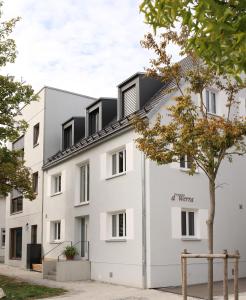 a white building with a black roof at Anderswo Apartments in Langenau
