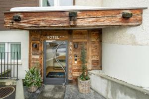 a hotel entrance with a door and plants in front at Hotel Sarazena in Zermatt