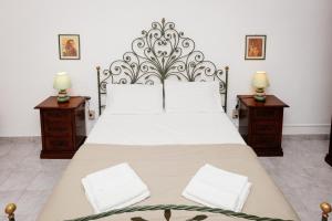 - une chambre avec un grand lit et 2 tables de chevet dans l'établissement Casa Vacanze Petronia-By Faendho, à Porto Torres