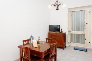 une salle à manger avec une table et une télévision dans l'établissement Casa Vacanze Petronia-By Faendho, à Porto Torres