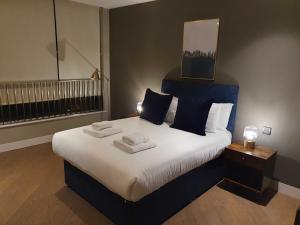 a bedroom with a large bed with two towels on it at StayLux Soho in London