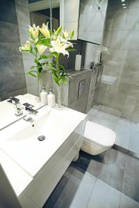 a bathroom with a sink and a vase of flowers at Apartament Targ Rybny - Gdańsk Old Town in Gdańsk