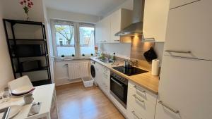 een keuken met een wastafel en een fornuis top oven bij Work & Stay Apartment with Balcony in Osnabrück