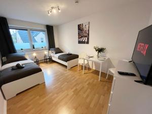 un soggiorno con 2 letti e una scrivania con TV di Work & Stay Apartment with Balcony a Osnabrück