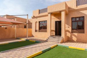 ein Haus mit Rasen davor in der Unterkunft Al Bada Hotel and Resort in al-Ain