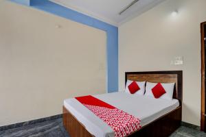 1 dormitorio con 1 cama con almohadas rojas en OYO J.B. BOARDING AND LODGING, en Bangalore