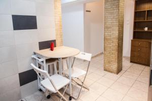 a small table and chairs in a room with tiles at Cozy apartment in Pireas in Piraeus