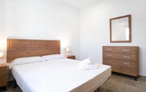 een slaapkamer met een bed, een dressoir en een spiegel bij Villa Montenmedio Juande in El Soto