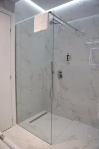 y baño con ducha y puerta de cristal. en Metro Hotel Terminal, en Tirana