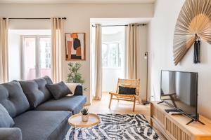 a living room with a couch and a tv at Akicity Saldanha City in Lisbon