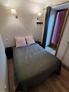 a bedroom with a bed with two pillows and a window at Appartement Fontargente in Ax-les-Thermes
