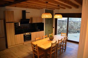 eine Küche und ein Esszimmer mit einem Holztisch und Stühlen in der Unterkunft Casas Las Hazas in La Cuesta