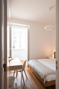 1 dormitorio con cama, escritorio y ventana en Amaro II - Sleek 2 bedroom apartment in Alcantara en Lisboa
