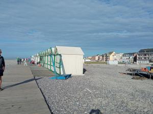 a group of people walking on a boardwalk at gite repos et tranquillité G in Cayeux-sur-Mer