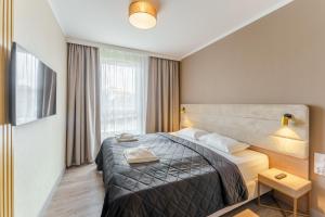 a hotel room with a bed and a window at Bel Mare Holiday Apartments near the Beach with PARKING by Renters in Międzyzdroje