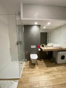 a bathroom with a shower and a toilet and a sink at Apartament przy plaży 9 in Mielno +36 photos