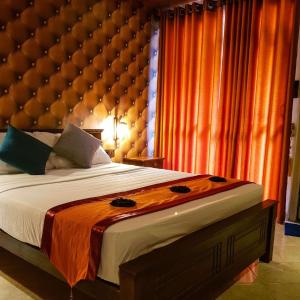 um quarto com uma cama grande e uma grande cabeceira acolchoada em Miracle Sand Country Resort em Mawatagama