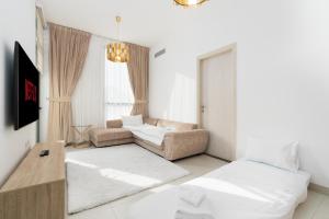 sala de estar con 2 camas y sofá en Modern 1-bedroom apartment in family-friendly residence with Swimming Pool, Gym & Free Parking., en Dubái