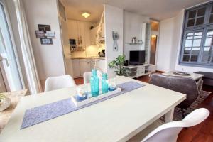 einen weißen Tisch mit Flaschen im Wohnzimmer in der Unterkunft Ferienpark - Haus F, App 0F0701 in Heiligenhafen