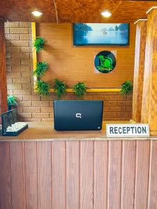 a reception counter with a laptop on top of it at Miracle Sand Country Resort in Mawatagama