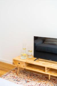 une télévision et deux verres sur une table basse dans l'établissement Amaro II - Sleek 2 bedroom apartment in Alcantara, à Lisbonne