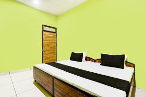 a bedroom with a large bed in a room with green walls at OYO Hotel H.R in Garhi Harsāru
