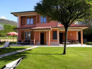 ein rosa Haus mit einem Baum im Hof in der Unterkunft Villino Blu private villa on the Chianti hils 102 pax in Loro Ciuffenna