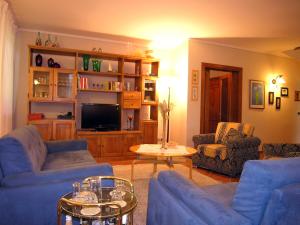 ein Wohnzimmer mit blauen Sofas und einem TV in der Unterkunft Villino Blu private villa on the Chianti hils 102 pax in Loro Ciuffenna