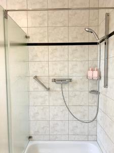 La salle de bains est pourvue d'une douche avec une porte en verre. dans l'établissement Haus Neuss-EG, à Neuss