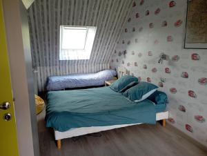 Cette petite chambre comprend un lit avec des draps bleus. dans l'établissement Chambre proche du circuit 2415 route des vignes, à Fillé