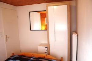 een slaapkamer met een spiegel en een bed erin bij NEU! Ferienhaus Weitblick am Großen Meer in Südbrookmerland