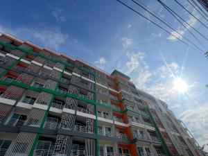 a tall apartment building with the sun in the sky at Zephyr Grand Hotel in Patong Beach