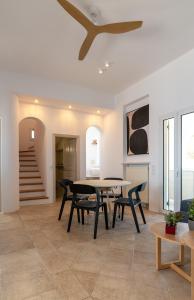 een eetkamer met een tafel en stoelen en een plafond bij La Chapelle Ouest & Guest suite in Agios Romanos