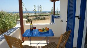 a table with a bowl of fruit and a bottle of wine at Villa Porto Rondo in Agios Prokopios
