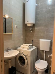 een badkamer met een wasmachine en een wastafel bij Sleep-Enjoy Apartment in Novi Sad