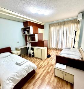 una camera con 2 letti, una scrivania e una sedia di Rolling Apartment Tirana - Near Blloku a Tirana