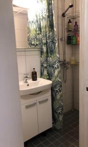 a bathroom with a sink and a shower curtain at Cosy apartment in the city center FREE PARKING in Kemi