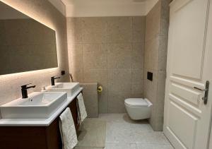 a bathroom with two sinks and a toilet at Palais Living Suite in Vienna